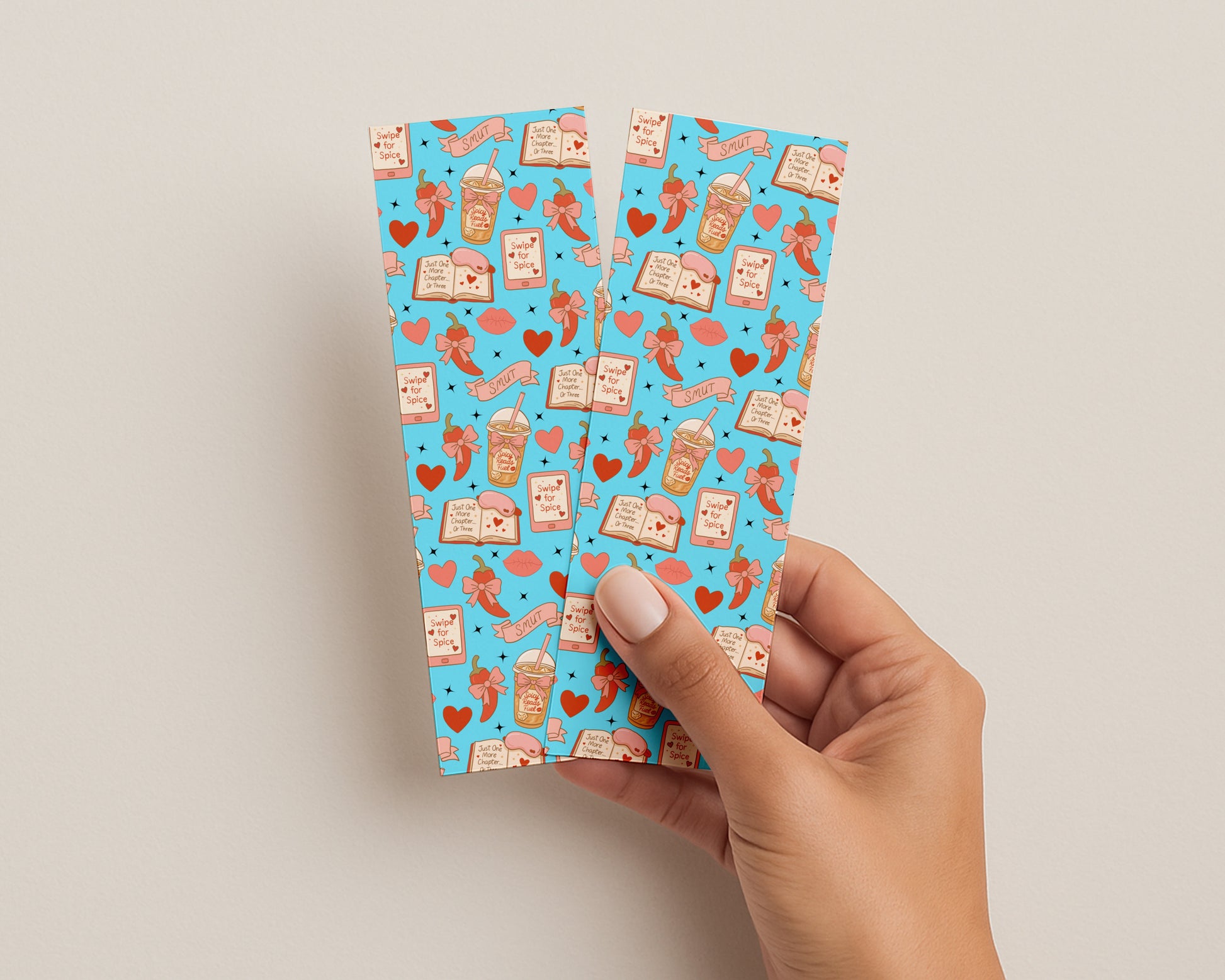 Hand holding a blue patterned bookmark against a beige background