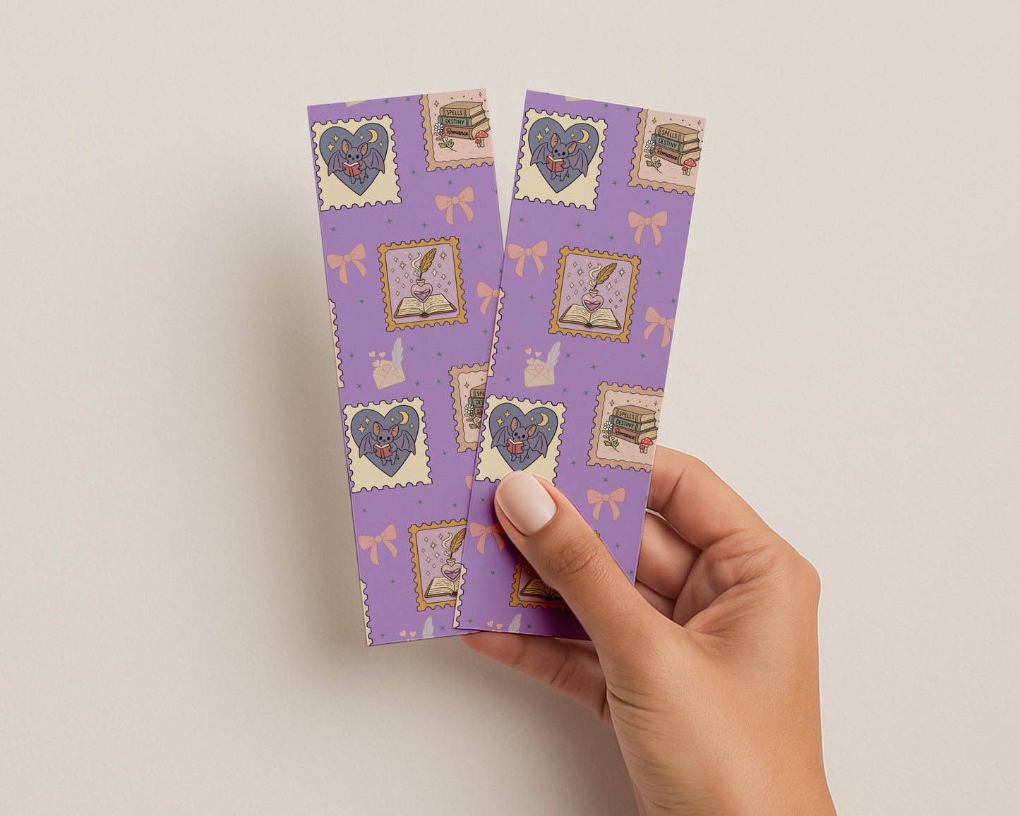 Hand holding purple bookmarks with romantasy decorative stamps on a light background