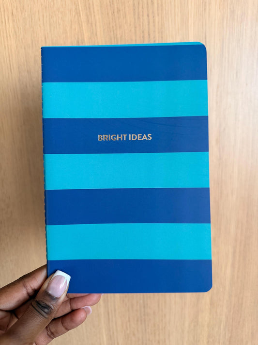 Blue striped notebook with horizontal teal and navy bands and the phrase “Bright Ideas” centered on the cover.