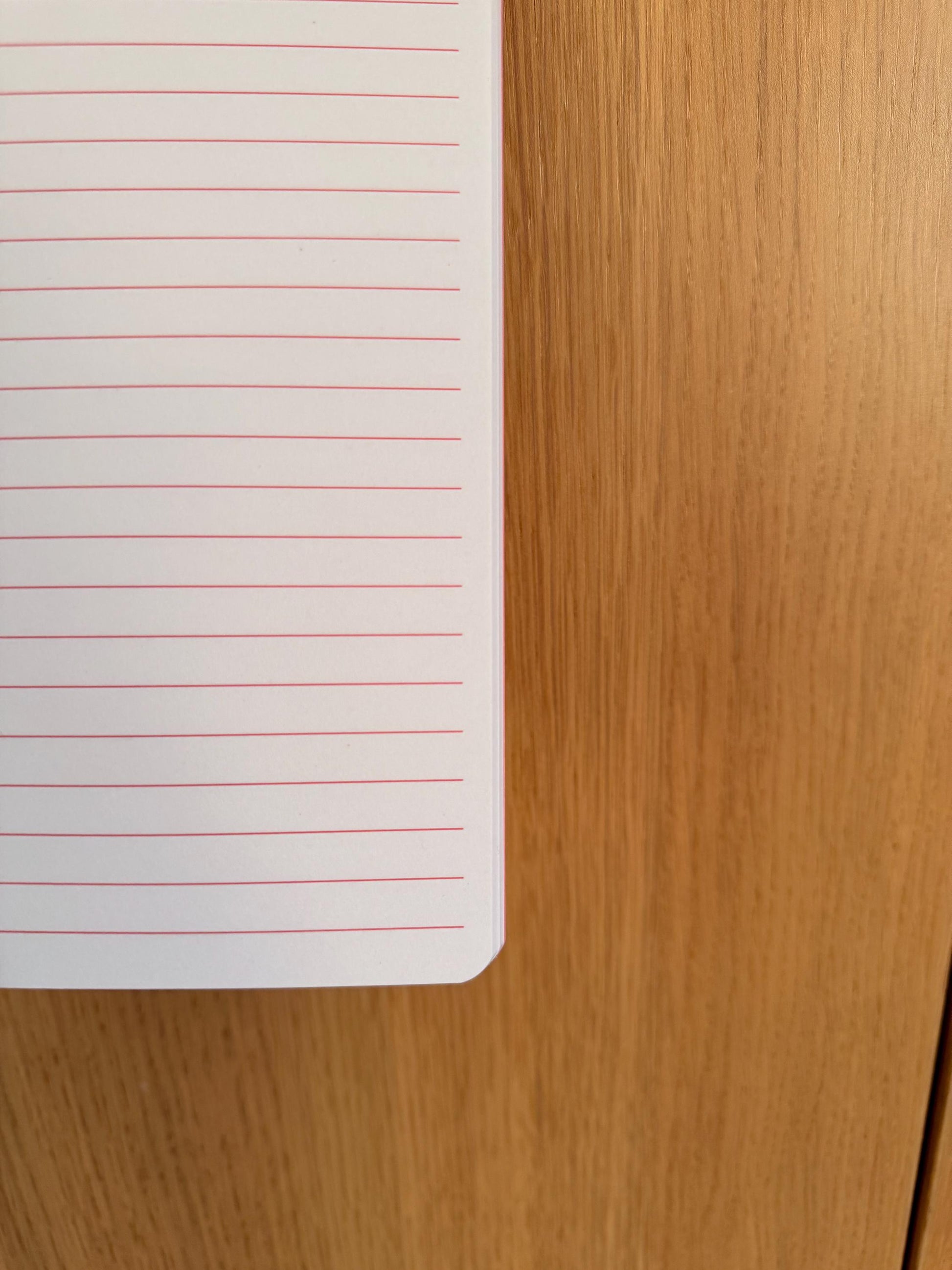 Close-up of a lined notebook page showing paper quality and line spacing.