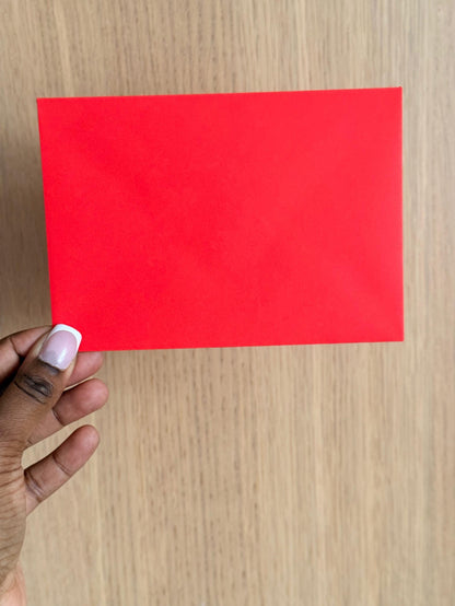 front of matching red envelope in hand